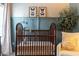 Cozy Bedroom features a wooden crib, floral wallpaper, and accents of calming blue at 2099 Lakeview Bend Way, Buford, GA 30519