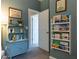 Cozy Bedroom showcasing a charming blue cabinet and a wall-mounted bookshelf filled with books at 2099 Lakeview Bend Way, Buford, GA 30519