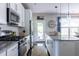 Open kitchen featuring white cabinets, stainless steel appliances, granite countertops, and backyard access at 2099 Lakeview Bend Way, Buford, GA 30519