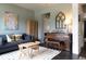 Comfortable living room features a sofa, vibrant artwork, and a cozy rug on dark hardwood floors at 2099 Lakeview Bend Way, Buford, GA 30519