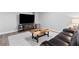 Cozy finished basement with a large TV, wood coffee table, leather couch, and white rug at 3581 Ridge Se Rd, Smyrna, GA 30080