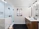 Modern bathroom featuring a double sink vanity, a walk-in shower with glass doors and black hardware at 3581 Ridge Se Rd, Smyrna, GA 30080