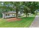 Charming painted brick home with mature trees, professionally landscaped lawn and sidewalk at 3581 Ridge Se Rd, Smyrna, GA 30080