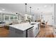 Open-concept kitchen featuring a gray kitchen island with marble countertops and stainless steel appliances at 3581 Ridge Se Rd, Smyrna, GA 30080