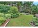 View of the well-maintained lush backyard with mature trees and shrubs at 3957 Marquette Nw Way, Kennesaw, GA 30144