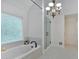 Bright bathroom featuring a soaking tub under a window and a glass shower with matte black hardware at 3957 Marquette Nw Way, Kennesaw, GA 30144