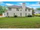 Back exterior view of a light-colored two-story home surrounded by the green yard at 3957 Marquette Nw Way, Kennesaw, GA 30144