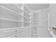 White walk-in closet with built-in shelves and drawers at 3957 Marquette Nw Way, Kennesaw, GA 30144
