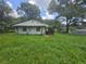 View of the home's back exterior with a covered porch and lush backyard showcasing the property's serenity at 4945 Campbellton Sw Rd, Atlanta, GA 30331