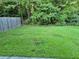 Spacious backyard featuring a lawn and wooden privacy fence surrounded by lush trees at 5570 Hampton Ct, Atlanta, GA 30349
