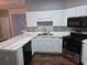 Well-lit kitchen featuring white cabinets, a sleek black microwave, and a modern gas range oven at 5570 Hampton Ct, Atlanta, GA 30349