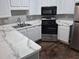 Modern kitchen with stainless steel refrigerator, gas range, white cabinets, and marble countertops at 5570 Hampton Ct, Atlanta, GA 30349