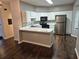 Bright kitchen featuring white cabinets, stainless steel appliances, and breakfast bar at 5570 Hampton Ct, Atlanta, GA 30349