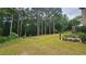 Expansive backyard with a manicured lawn, mature trees, and lush landscaping at 2819 Heritage Oaks Cir, Dacula, GA 30019