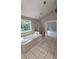 Bright bathroom featuring soaking tub, walk-in shower, and tile flooring at 2819 Heritage Oaks Cir, Dacula, GA 30019