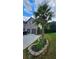 Home with an attached two-car garage, a circular stone bordered garden, and mature palm tree at 2819 Heritage Oaks Cir, Dacula, GA 30019