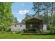 Home's backyard featuring a screened porch overlooking the manicured lawn and raised garden beds at 3123 Deshong Dr, Stone Mountain, GA 30087