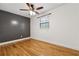 Cozy bedroom featuring a dark accent wall, wood floors, ceiling fan and natural light at 3123 Deshong Dr, Stone Mountain, GA 30087