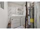 Practical laundry area featuring a washer, dryer, water heater, and storage shelves at 3123 Deshong Dr, Stone Mountain, GA 30087