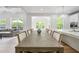 Bright dining area featuring a large wood table, stylish chairs, and ample natural light at 3755 Valleyway Rd, Cumming, GA 30040
