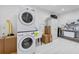 Functional laundry room with stacked washer and dryer, utility sink, and ample storage at 3755 Valleyway Rd, Cumming, GA 30040