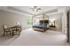 Spacious main bedroom features a tray ceiling, four-poster bed, sitting area and plenty of natural light at 3755 Valleyway Rd, Cumming, GA 30040