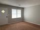 Cozy living room featuring neutral walls, brown carpet and natural light from a large window at 499 Oak Way, Lawrenceville, GA 30046