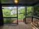 Wooden back porch with railing overlooks backyard with view of another house at 1497 Elizabeth Ln, East Point, GA 30344