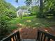 This overgrown backyard, as seen from the porch, includes lush greenery and mature trees at 1497 Elizabeth Ln, East Point, GA 30344
