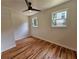 Cozy bedroom with hardwood floors, two windows providing natural light, and a ceiling fan for added comfort at 1497 Elizabeth Ln, East Point, GA 30344
