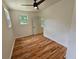 Bright bedroom showcasing hardwood floors, a ceiling fan, two windows, and white walls, creating a serene atmosphere at 1497 Elizabeth Ln, East Point, GA 30344