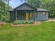 Charming exterior view of well-maintained home with inviting front yard and bright, welcoming, yellow front door at 1497 Elizabeth Ln, East Point, GA 30344