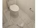 The well-maintained toilet matches the marble tile in the cozy, clean bathroom at 1497 Elizabeth Ln, East Point, GA 30344