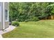 A view of a well-kept backyard features lush, green grass and mature trees at 2625 Morningside Nw Trl, Kennesaw, GA 30144