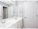 A bright bathroom featuring double sinks, a large mirror, and white cabinets at 2625 Morningside Nw Trl, Kennesaw, GA 30144