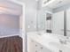 A bright bathroom featuring double sinks, a large mirror, and white cabinets, with bedroom access at 2625 Morningside Nw Trl, Kennesaw, GA 30144