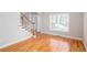 Bright living room with hardwood floors and staircase featuring large windows and neutral paint colors at 2625 Morningside Nw Trl, Kennesaw, GA 30144