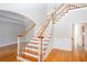 Elegant staircase with hardwood steps, white risers, and wainscotting in an open floor plan at 2625 Morningside Nw Trl, Kennesaw, GA 30144