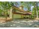 A side view of a two-story home with a deck, a garage, and a paved driveway at 3957 Woodland Cir, Conyers, GA 30013