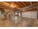 Spacious unfinished basement with stairs, garage door, and concrete floor at 3957 Woodland Cir, Conyers, GA 30013