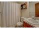 Bathroom with shower and curtain, tiled floors, wood vanity, and oval sink at 3957 Woodland Cir, Conyers, GA 30013