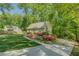The front of this charming home shows a curved sidewalk and a driveway leading to the house with mature landscaping at 3957 Woodland Cir, Conyers, GA 30013