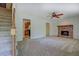 A spacious living room featuring a fireplace, staircase, and neutral-colored carpet at 3957 Woodland Cir, Conyers, GA 30013