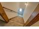 Carpeted stairs with wood railing lead to the upper levels of the home at 3957 Woodland Cir, Conyers, GA 30013