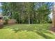 Picturesque backyard with lush green grass, privacy trees, and partial views of the home's deck at 419 Crestmont Ln, Canton, GA 30114
