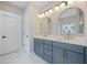 Stylish bathroom featuring double vanity with blue cabinets, marble floors, and modern fixtures at 419 Crestmont Ln, Canton, GA 30114