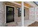Inviting front porch with brick accents, a black front door, and a well-lit entryway at 419 Crestmont Ln, Canton, GA 30114