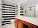Bright bathroom featuring a white vanity, a large mirror, and a shower with a striking black-and-white striped curtain at 5025 Bishops Row Row, Austell, GA 30106