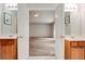 Bathroom featuring double vanities, framed mirrors, and an open doorway to bedroom with ceiling fan at 5025 Bishops Row Row, Austell, GA 30106