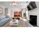 Virtually staged living room with fireplace, couch, and an open floor plan leading to the kitchen at 5025 Bishops Row Row, Austell, GA 30106
